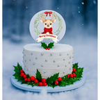 White cake with Christmas decorations including a reindeer topper and holly leaves on a snowy background.