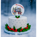 White Christmas cake with decorative elements and a 'Merry Christmas' topper against a snowy background.