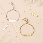 Two personalized adjustable bar bracelets—one gold and one silver—styled on a cream and beige background with frosted foliage. Engraved with “Love you always” and “A & N 15/02/2024,” ideal for gifting and keepsakes.