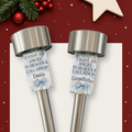 Two stainless steel solar memorial lights with personalised messages for Daddy and Grandfather, featuring angel wings and blue bows, set against a minimalistic Christmas background with snowflakes and festive greenery.
