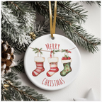 Ceramic ornament showing three festive stockings hanging from a pine branch, with candy canes and berries, surrounded by pine needles and a white star, with “MERRY CHRISTMAS” in red.