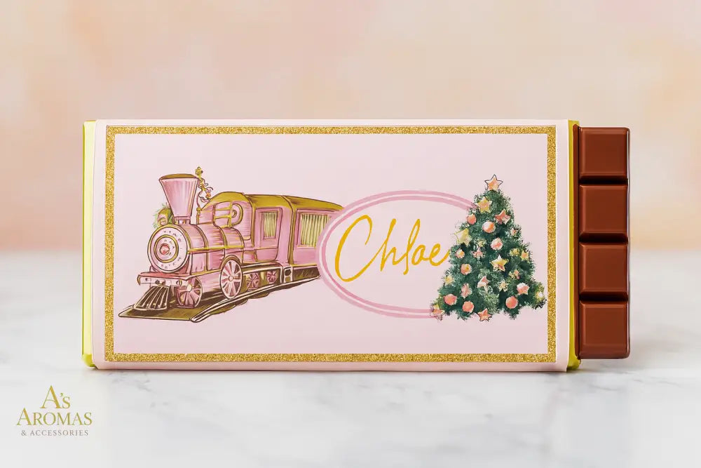 Customised Christmas chocolate bar with pink vintage train and decorated tree on pastel wrapper, personalised with the name Chloe, displayed on marble table with soft beige and blush background.